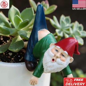 May include: A white ceramic mug with a black handle and the text "But First, Coffee" in a black, handwritten-style font. The mug is on a white surface.