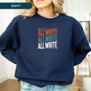 May include: Navy blue sweatshirt with the text "ALL WRITE" in red, gray, and white. The sweatshirt has a white collar and is a casual style.