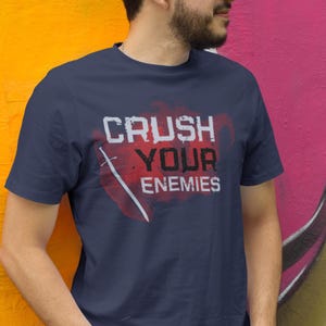 May include: A navy blue t-shirt with a red and white graphic that says "Crush Your Enemies".