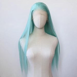 Puede incluir: Una peluca larga, recta, azul claro hecha de cabello sintético. La peluca está peinada con raya en medio y cae hasta los hombros.