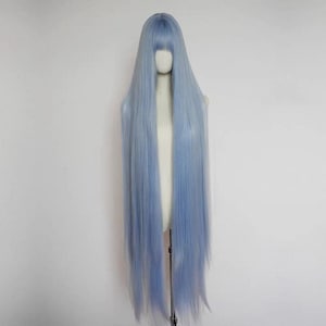May include: A long, light blue wig with a blunt fringe, displayed on a mannequin. The wig features straight, flowing hair that extends well past the shoulders. The color is a soft, pastel blue, creating a striking visual.