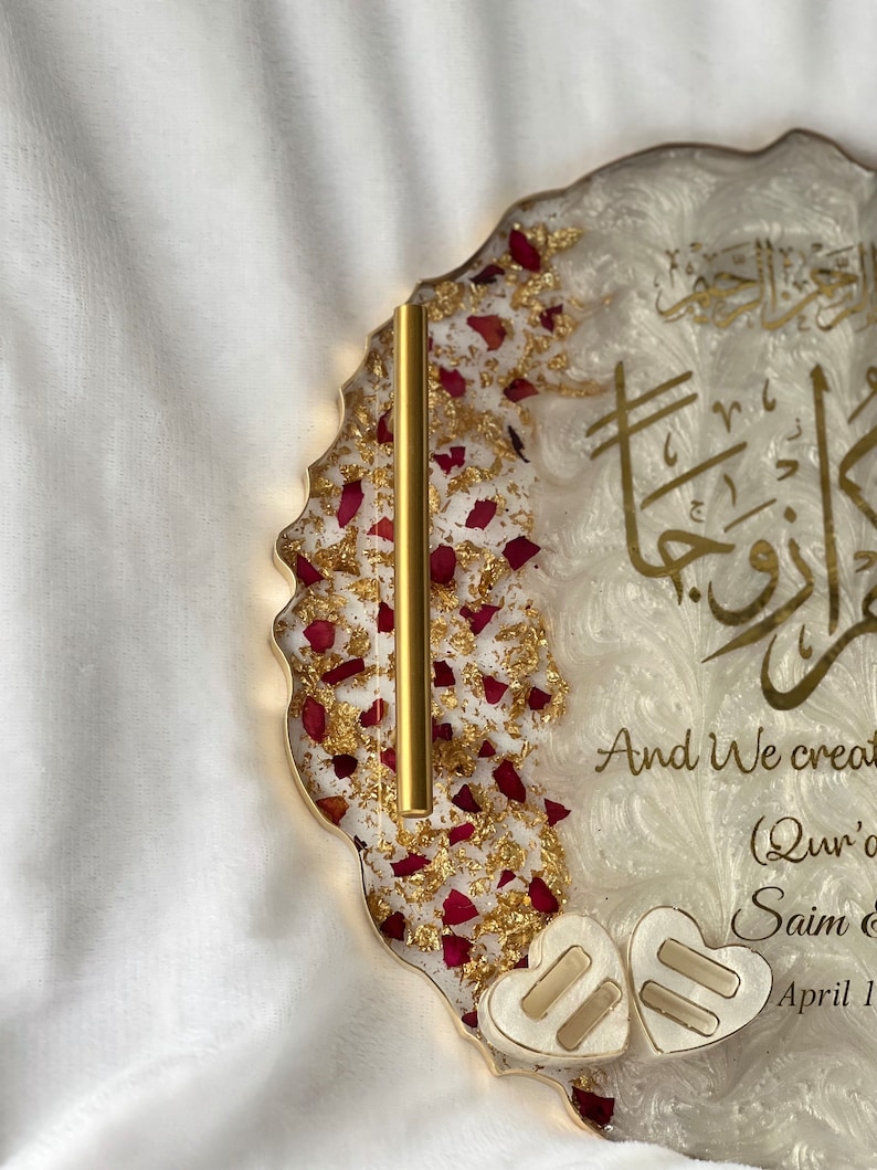 May include: A decorative resin tray with gold trim, featuring gold leaf, red rose petals, and gold Arabic calligraphy. The tray includes the text "And We created..." and two heart-shaped accents.