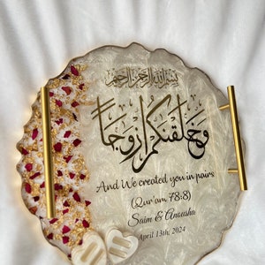 May include: A decorative resin tray with gold handles and edges. The tray features gold calligraphy and the English text "And We created you in pairs." It is decorated with red rose petals and two heart-shaped embellishments. The date April 13th, 2024 is also included.