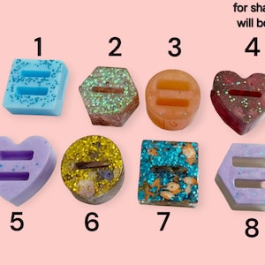 May include: A collection of eight decorative resin pieces in various shapes, including squares, hexagons, circles, and hearts. Each piece features a double-bar symbol and is filled with glitter or small decorative elements. The text "for shape only (color will be same as the tray)" is visible.