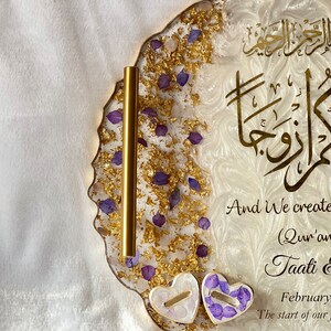 May include: A decorative resin tray with gold leaf accents, purple flower petals, and gold calligraphy. The tray has a wavy edge and includes two heart-shaped elements. Text on the tray reads "And We created you in pairs".