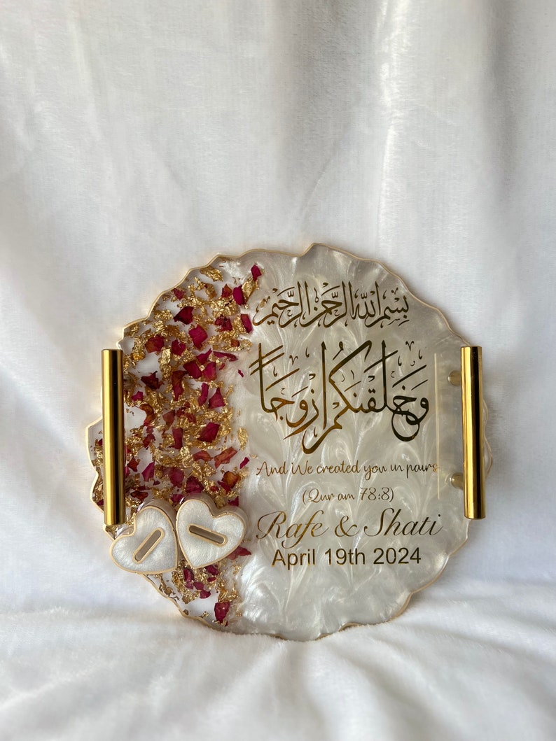 May include: A decorative, resin tray with gold trim and handles. The tray features gold script, dried rose petals, and two heart-shaped accents. The text includes names and a date.