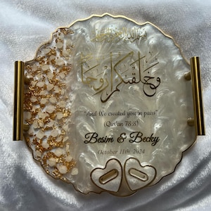 May include: A decorative resin tray with gold accents and handles. The tray features gold calligraphy and the text "And We created you in pairs" with the names "Besim & Becky" and the date "October 11th. 2024".
