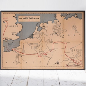 May include: Framed vintage map depicting the route of the 501st Engineer Combat Battalion. The map features a beige background with gray and red lines marking the route through Europe. Text includes country names and the title.