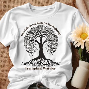 May include: White t-shirt with a black tree design and the text "Stem Cells, Strong Roots for New Beginnings" above the tree and "Transplant Warrior" below the tree.
