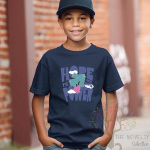 May include: A navy blue t-shirt with a graphic of a blue bird carrying a pink heart with the text "HOPE IS MY SUPER POWER" in colorful letters.