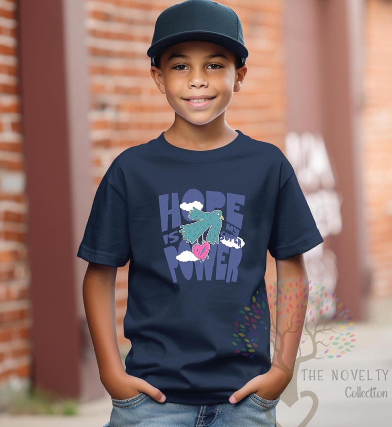 May include: A navy blue t-shirt with a graphic of a blue bird carrying a pink heart with the text "HOPE IS MY SUPER POWER" in colorful letters.