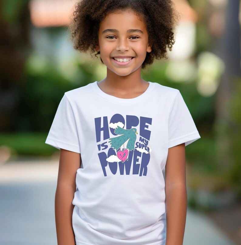 May include: White t-shirt with a blue graphic that says "Hope is my super power" with a green bird holding a pink heart.