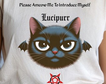 May include: A beige t-shirt featuring a black cat with bat wings and the text "Please Ameow Me To Introduce Myself Lucipurr". A red pentagram is below the cat graphic. The shirt is worn by a person.