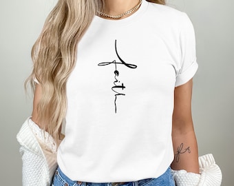 May include: White t-shirt with a black cross and the word "faith" written vertically inside the cross.