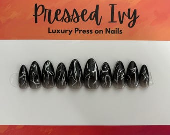 May include: A set of luxury press-on nails with a black and gray gradient design. Each nail features a white, abstract line pattern. The nails are displayed on a white card with the text "Pressed Ivy Luxury Press on Nails".