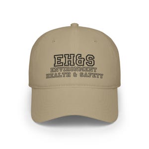 Puede incluir: Una gorra de béisbol de color beige con texto bordado en negro que dice "EH&S Environment Health & Safety".