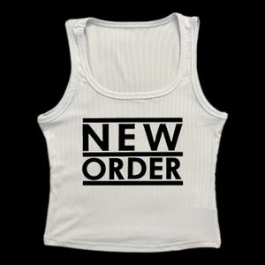 May include: White ribbed tank top with the words "NEW ORDER" in bold black capital letters. The text is centered and framed by horizontal black lines. The top has a scoop neck and a fitted silhouette.