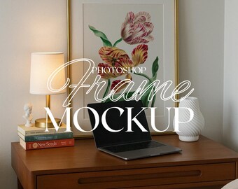 May include: A framed floral print with red, yellow, and green tulips hangs above a wooden desk. A laptop, lamp, books, and a white vase are on the desk. The words "Photoshop Frame Mockup" are overlaid on the image.