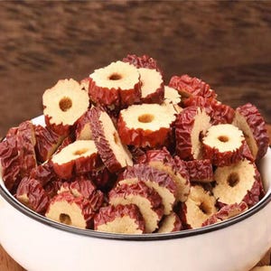May include: A bowl filled with dried red dates, also known as jujubes, sliced into rings. The dates are a popular ingredient in traditional Chinese medicine and are often used in soups, teas, and desserts.