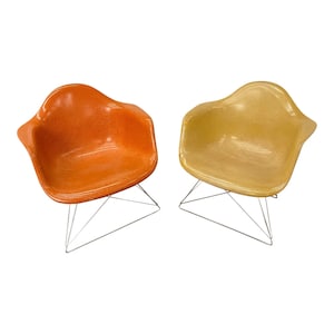 May include: Two mid-century modern chairs with a chrome wire frame and fiberglass seats. One chair is orange and the other is yellow.