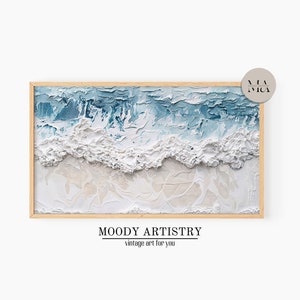 May include: A framed abstract painting of a seascape with white and blue textured paint. The painting is framed in a light wood frame. The text "MOODY ARTISTRY vintage art for you" is below the painting.