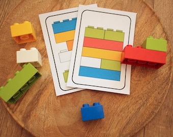 May include: A set of colorful plastic building blocks with a printable worksheet for a building activity. The worksheet shows a tower with different colored blocks.