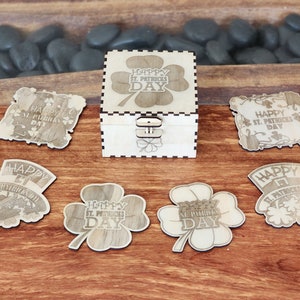 May include: A wooden box with a shamrock design and the text "Happy St. Patricks Day" on the lid. The box is surrounded by six smaller wooden cutouts with similar designs and text.