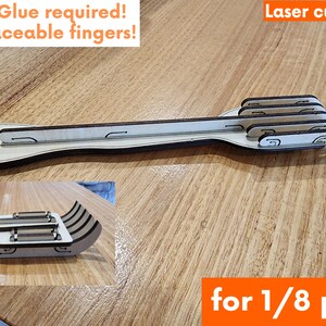 K&ouml;nnte beinhalten: Eine Holzh&auml;nder mit f&uuml;nf Fingern, hergestellt aus 1/8 Zoll Sperrholz. Die Hand ist so konzipiert, dass sie ohne Klebstoff montiert werden kann und austauschbare Finger hat. Das Bild enth&auml;lt den Text "Laserschnittdateien f&uuml;r 1/8 Zoll Sperrholz".