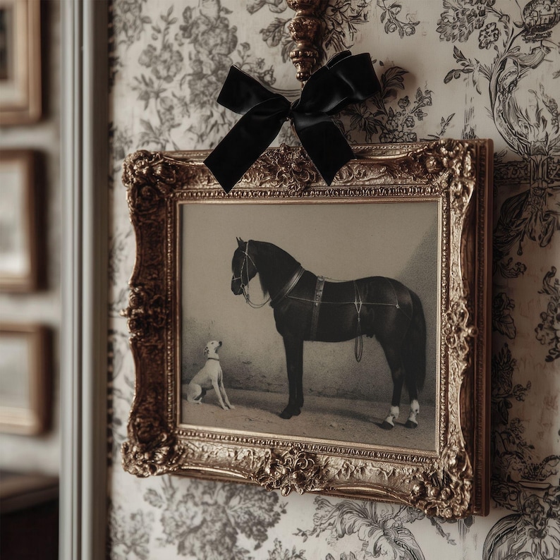 May include: A framed print featuring a black horse and a small white dog. The print is in a gold ornate frame and is adorned with a black velvet bow. The background is a floral wallpaper.