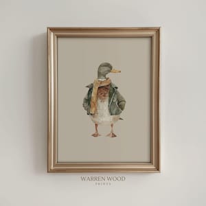 May include: Watercolor print of a duck wearing a green jacket and a tan scarf, standing with its hands in its pockets. The duck has a yellow beak and is set against a neutral background, framed in a gold frame. The text "WARREN WOOD PRINTS" is at the bottom.