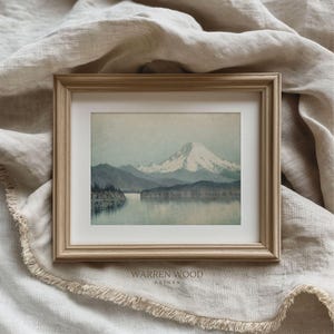 May include: A framed landscape print featuring a serene mountain scene with a snow-capped peak reflected in a calm lake. The artwork is in a light wooden frame, with the text "WARREN WOOD PRINTS" at the bottom.