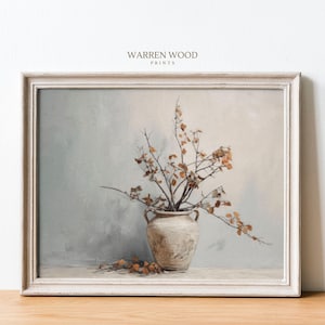 May include: A framed painting of a white ceramic vase with dried branches and leaves in shades of brown and beige against a light blue background. The painting is in a white frame with a subtle distressed finish.