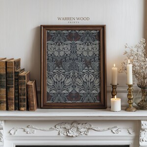 May include: A framed print with a floral pattern in shades of gray, blue, and burgundy, displayed on a white mantelpiece. The print is in a dark brown wooden frame. The text "WARREN WOOD PRINTS" is at the top. Lit candles and antique books are also visible.