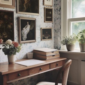 May include: A vintage-style home office with a wooden desk, drawers, and a chair. The wall is adorned with framed artwork and floral wallpaper. A window with potted plants provides natural light, creating a cozy and artistic workspace.