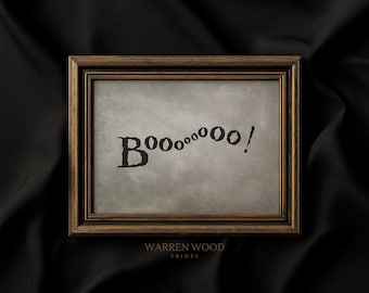 May include: A framed print with the word "Boo" in a spooky font. The word is followed by a series of "o"s and an exclamation point. The frame is brown, and the background is a muted gray. The text "WARREN WOOD PRINTS" is at the bottom.