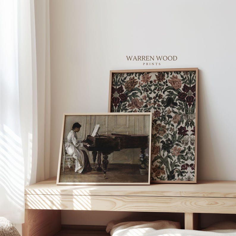 May include: Two framed prints on a wooden surface. One print depicts a person playing a piano, the other features a floral pattern in shades of burgundy, green, and cream. The text "WARREN WOOD PRINTS" is visible.