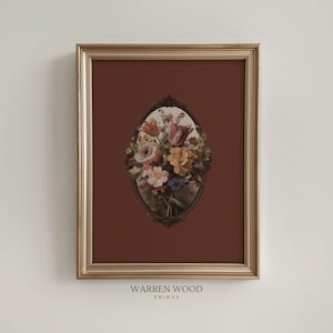 Puede incluir: Una impresión floral enmarcada con un ramo de flores en un marco ovalado sobre un fondo rojo oscuro. La impresión está en un marco dorado. El texto "WARREN WOOD PRINTS" está en la parte inferior.