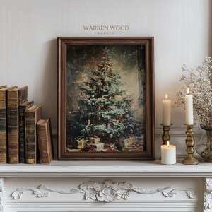 May include: A framed print of a Christmas tree with gifts beneath it, displayed on a white mantelpiece. The print is in a dark brown frame, and the text "WARREN WOOD PRINTS" is visible at the top. Lit candles and antique books are also present.