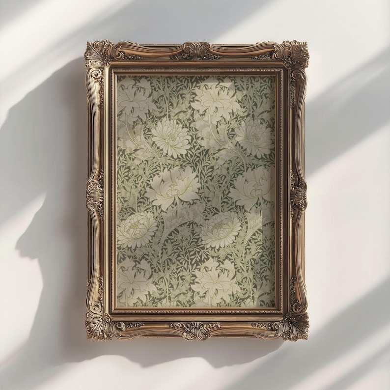 May include: A gold ornate frame with a floral print inside. The print features a repeating pattern of white flowers and green leaves.