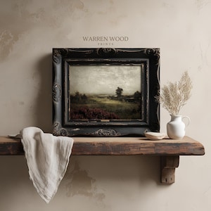 May include: A framed landscape print with a black ornate frame. The print depicts a field with red flowers and a tree under a cloudy sky. The text "WARREN WOOD PRINTS" is visible at the top. The print is displayed on a wooden shelf.