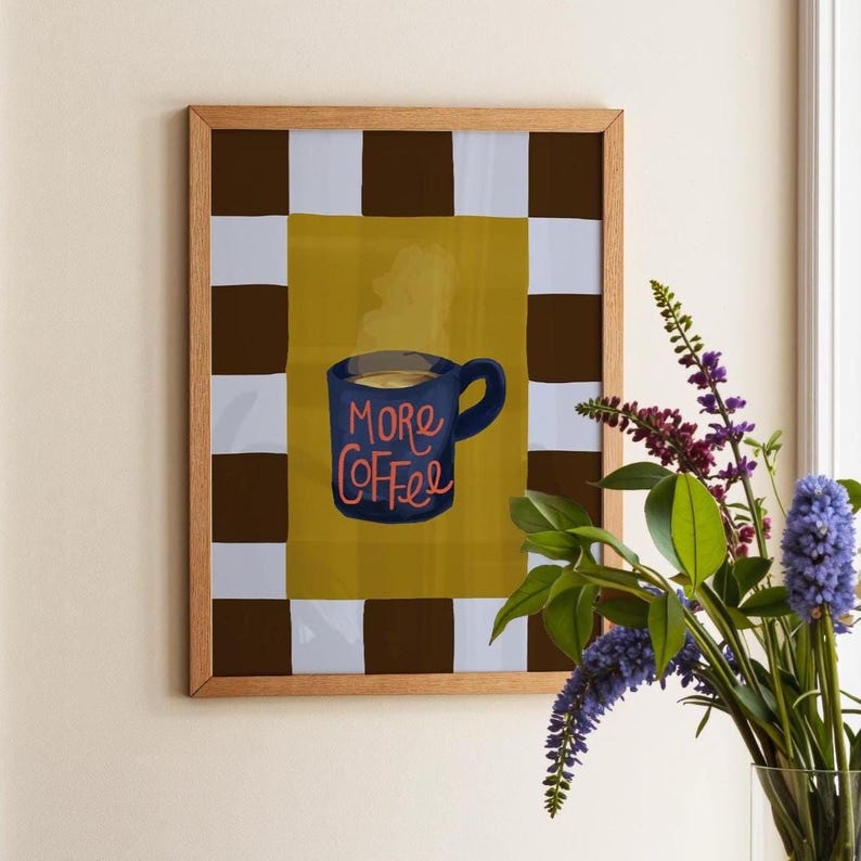 Hand-illustrated More Coffee print featuring a steaming navy blue mug and bold checkered border in chocolate brown and powder blue. Perfect kitchen wall art or gift for coffee lovers. Giclée printed to last.