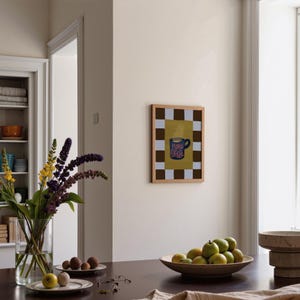 a cozy dining area with a wooden table set with a vase of purple flowers, a bowl of fruit, and a framed picture on the wall.