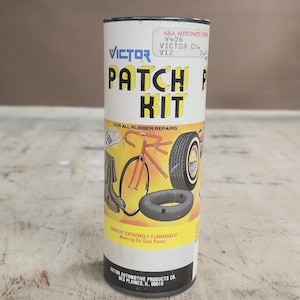 May include: A cylindrical Victor Patch Kit for rubber repairs. The kit's label features the brand name, product details, and illustrations of tires, a bicycle, and a boot. The text "DANGER! EXTREMELY FLAMMABLE!" is also visible.