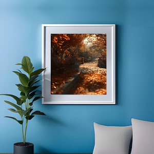 May include: A framed photograph of a path through a woodland in autumn. The path is covered in fallen leaves and the trees are a mix of orange, red, and yellow.