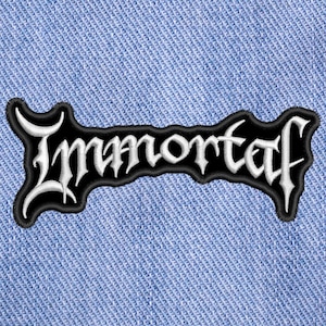 Peut inclure: Écusson brodé noir et blanc avec le mot "Immortal" écrit en police gothique. Le patch a une bordure noire et est posé sur un fond en denim bleu clair. Idéal pour les vêtements ou accessoires.