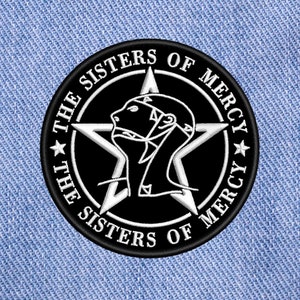 Könnte beinhalten: Schwarz-weiß gestickter Patch mit einem fünfzackigen Stern und einem stilisierten menschlichen Kopf. Der Text "The Sisters of Mercy" ist um den Stern herum geschrieben.