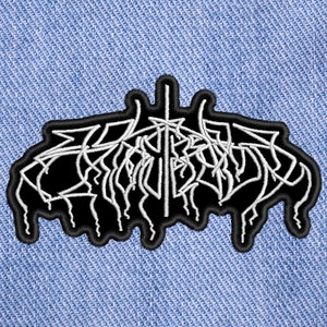 May include: Black and white embroidered patch with the word "Emperor" written in a stylized font.