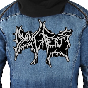 May include: A black denim jacket with a white embroidered patch on the back that says "SLAUGHTER".