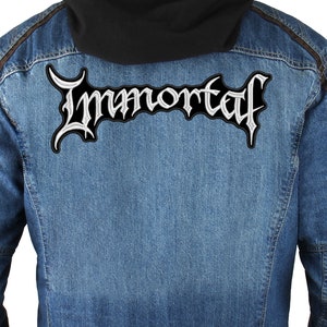 Peut inclure: Une veste en jean avec un patch brodé blanc qui dit "Immortal" au dos.
