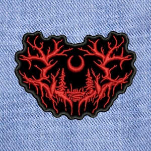 Pode incluir: Etiqueta bordada preta e vermelha com uma lua crescente e duas árvores no centro. As árvores têm ramos que se estendem para os lados e formam um formato de coração.